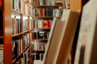 Library aisle with books on wooden shelves