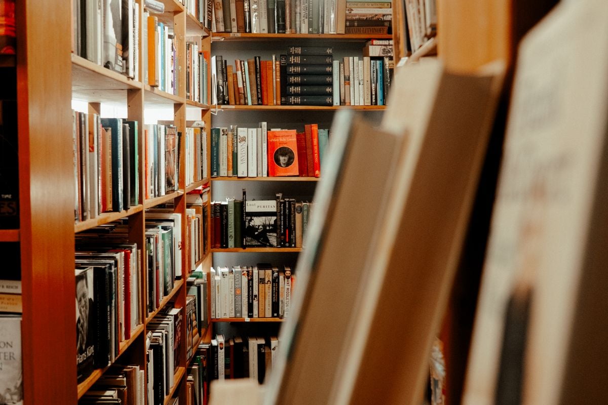 Library aisle with books on wooden shelves
