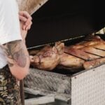 Whole pigs roasting on a large outdoor grill