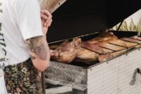 Whole pigs roasting on a large outdoor grill