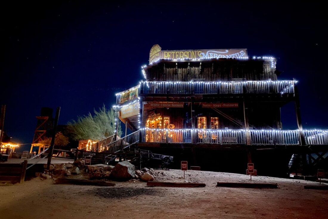 Rustic wooden western saloon building lit up at night