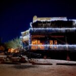 Rustic wooden western saloon building lit up at night