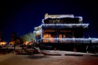 Rustic wooden western saloon building lit up at night