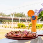 Pizza and craft beer on an outdoor railing, ideal for lakeside dining in Sparta NJ