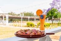 Pizza and craft beer on an outdoor railing, ideal for lakeside dining in Sparta NJ