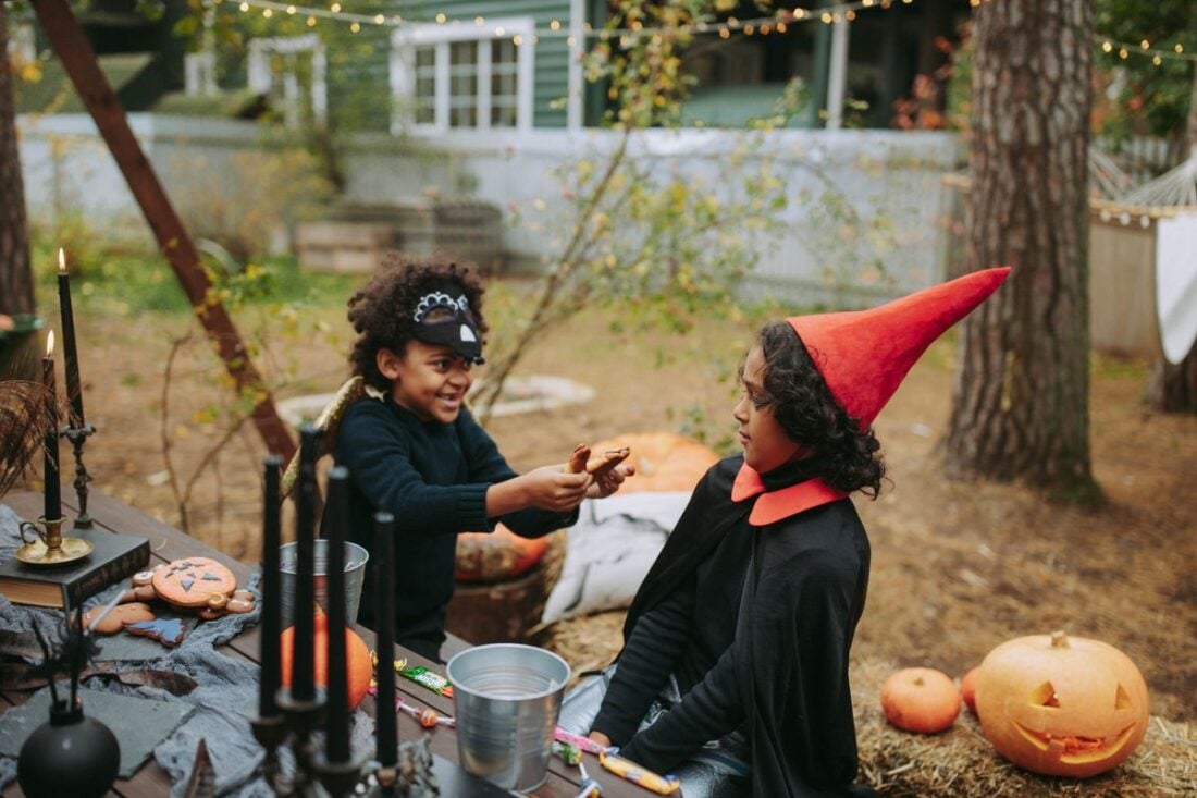 Children in Halloween costumes outdoors in fall