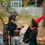Children in Halloween costumes outdoors in fall