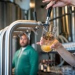Beer being poured from a tap at a brewery taproom