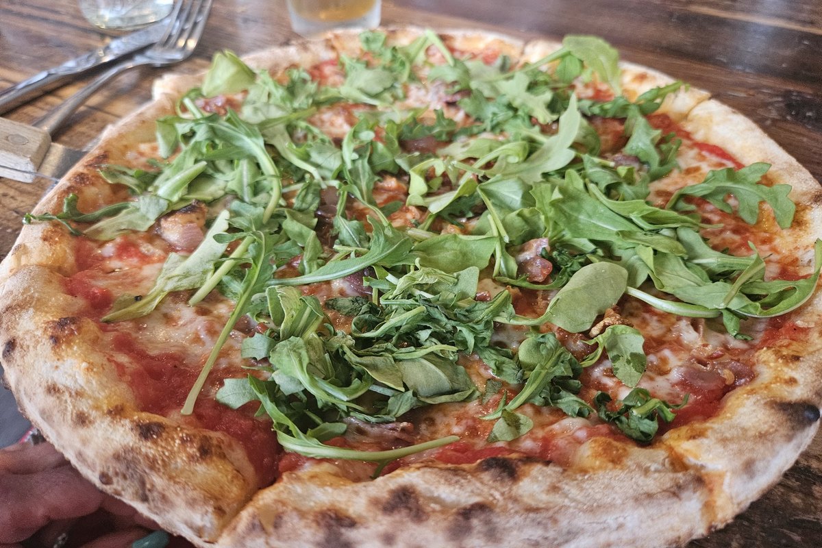 Oven-baked pizza topped with fresh arugula at Brick & Brew in Franklin, NJ