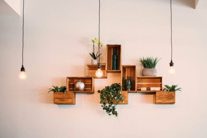 Rustic wooden crate shelves with plants and hanging lights, suggesting a local antiques and goods shop vibe