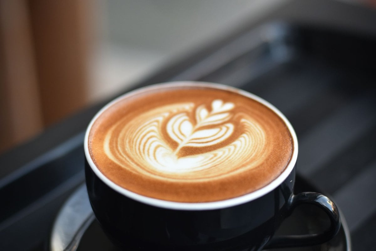 A cappuccino with latte art on a cafe table