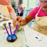 Child shows off a clay creature made at The ART Project kids art studio in Sparta, NJ