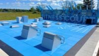 Blue outdoor Fitness Court with seven exercise stations on the Sussex County Community College campus in Newton, NJ