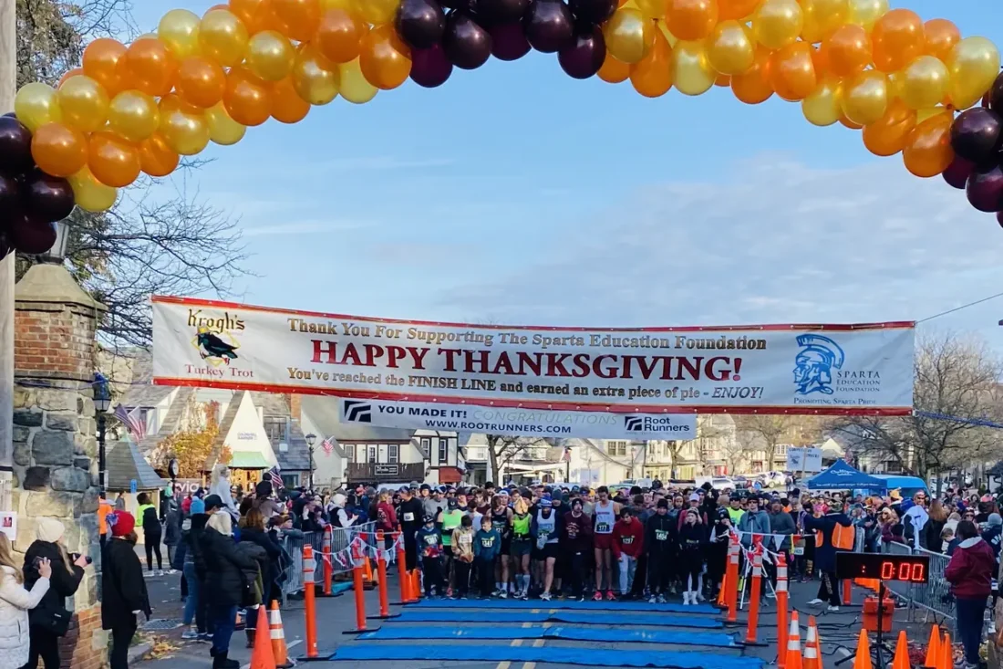 Runners at the Sparta Education Foundation Turkey Trot finish line arch in Sparta, NJ on Thanksgiving morning