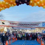 Runners at the Sparta Education Foundation Turkey Trot finish line arch in Sparta, NJ on Thanksgiving morning