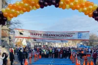 Runners at the Sparta Education Foundation Turkey Trot finish line arch in Sparta, NJ on Thanksgiving morning