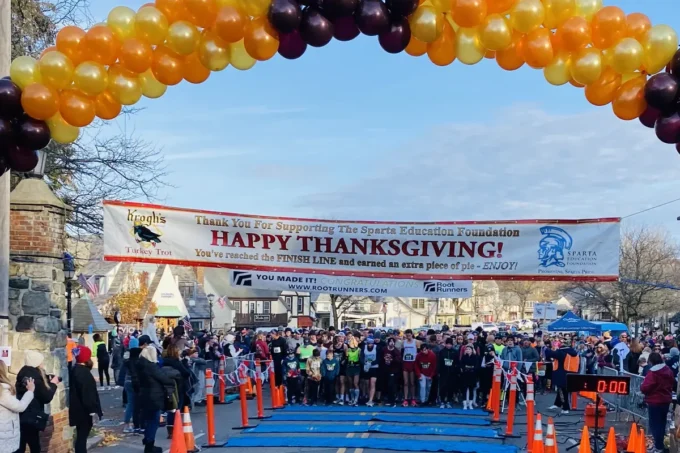 Runners at the Sparta Education Foundation Turkey Trot finish line arch in Sparta, NJ on Thanksgiving morning