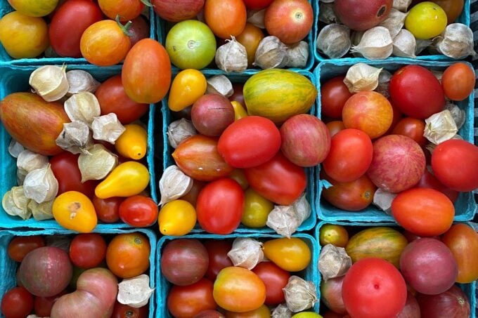 Heirloom tomatoes and ground cherries in baskets at Sparta NJ farmers market