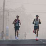 Runners leading a road race on a foggy morning