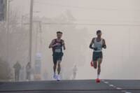 Runners leading a road race on a foggy morning