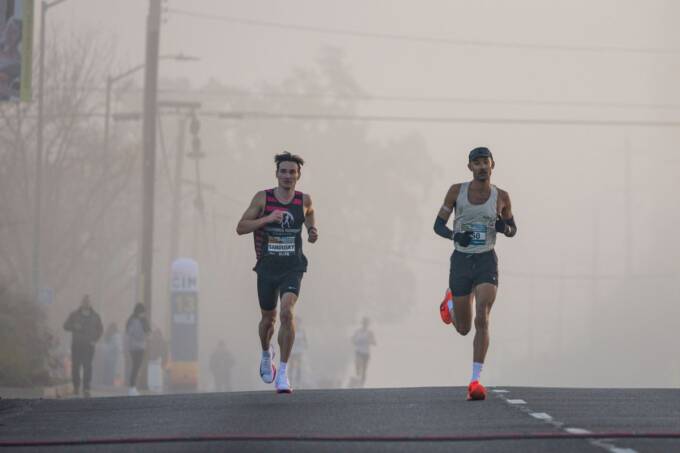 Runners leading a road race on a foggy morning