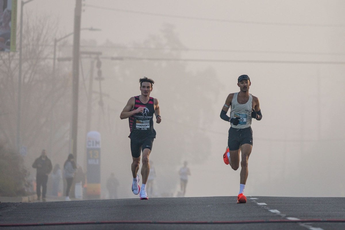 Runners leading a road race on a foggy morning