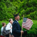 A veteran carrying an American flag at a patriotic parade